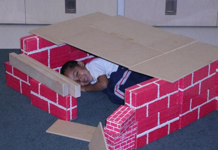 Child playing with blocks and building a fort.