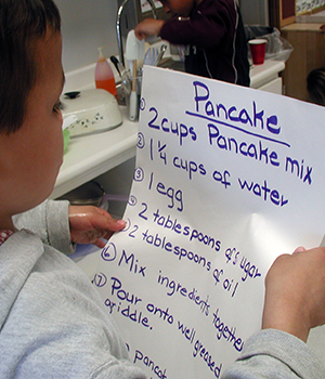 Toddler reading a recepie.