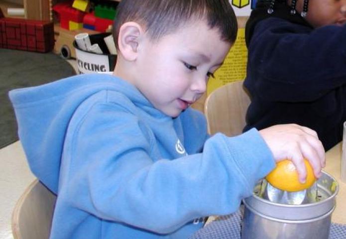 Child using juice press.