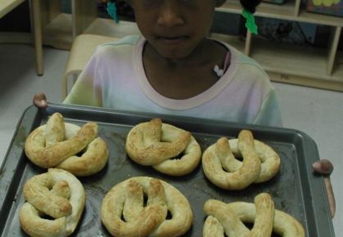 Child baking pretzels.