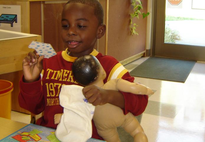 Child playing with a doll.