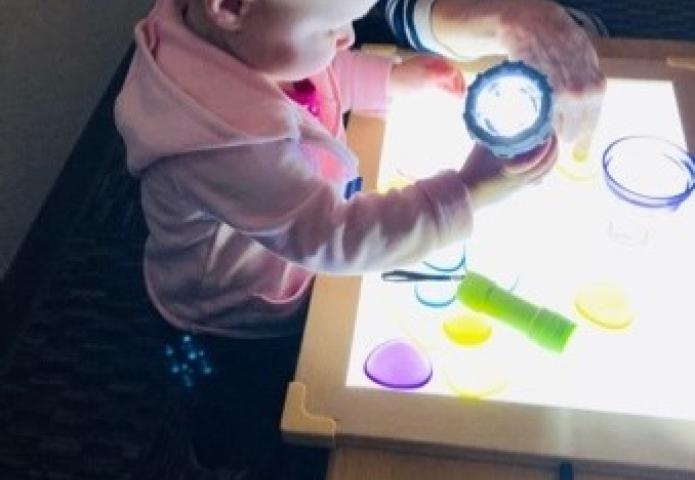 Infant playing with a light.