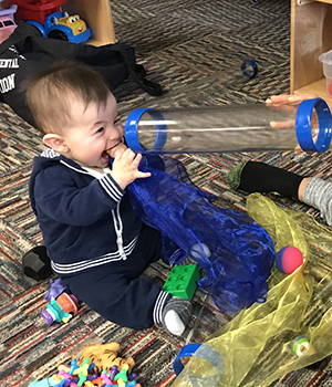 Infant watching through a tube.