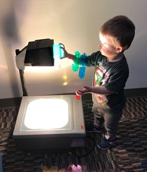 Infant using overhead projector.