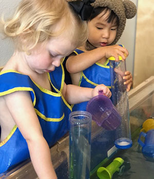 Two toddlers playing with containers.