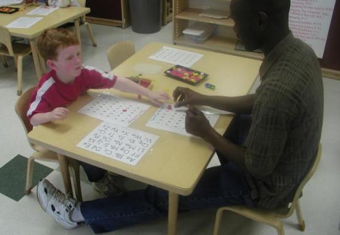 Playing games with a student at a table.