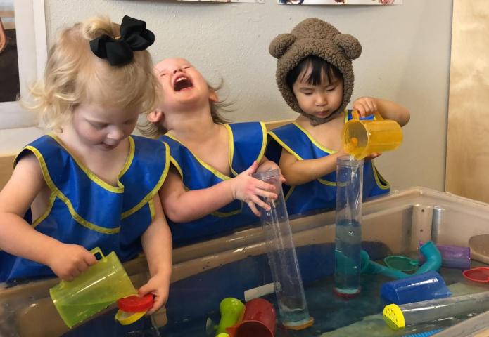 Blue dress girls playing in water.