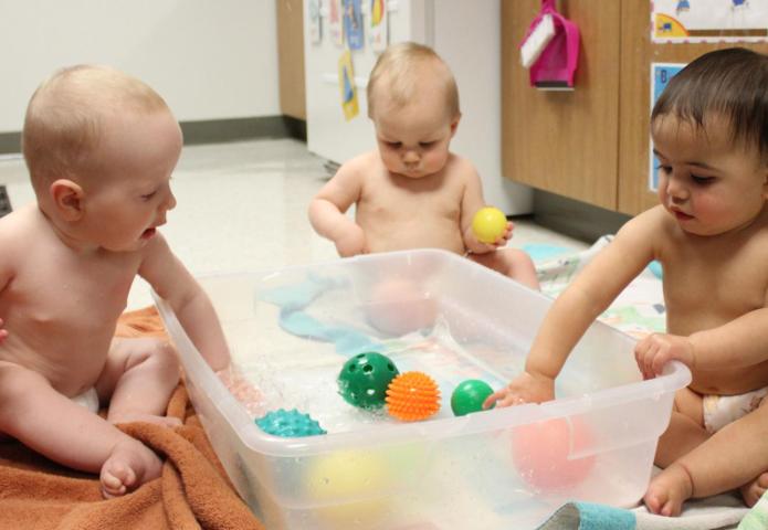 Babies playing in a tub.