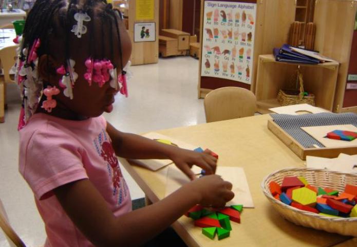 Child playing with shapes at a table.