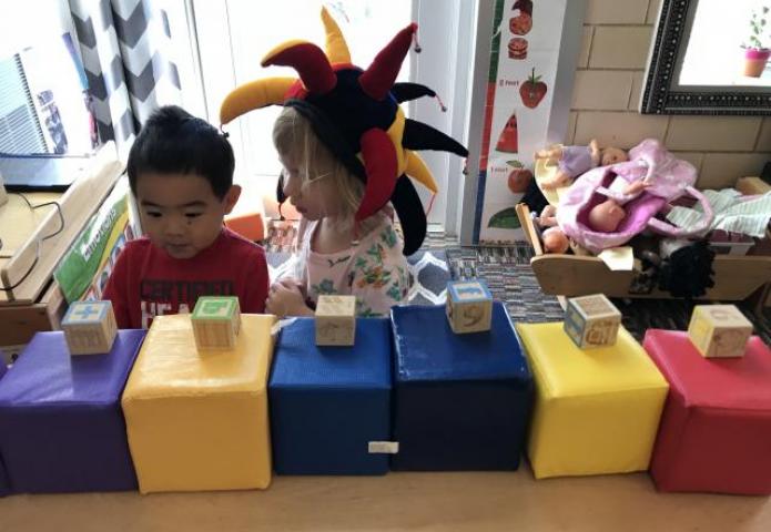 Children playing with oversized blocks.