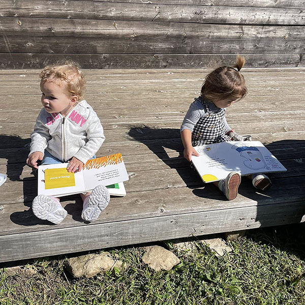 Two toddler holding books.
