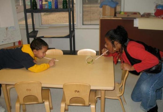 Student and a teacher playing at a table.