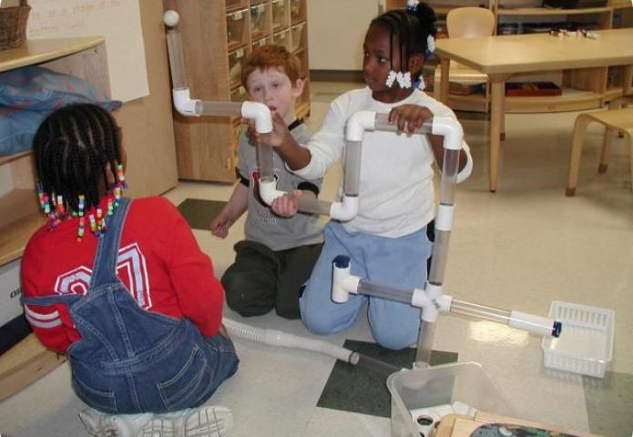 Students playing with tubes and connectiors.