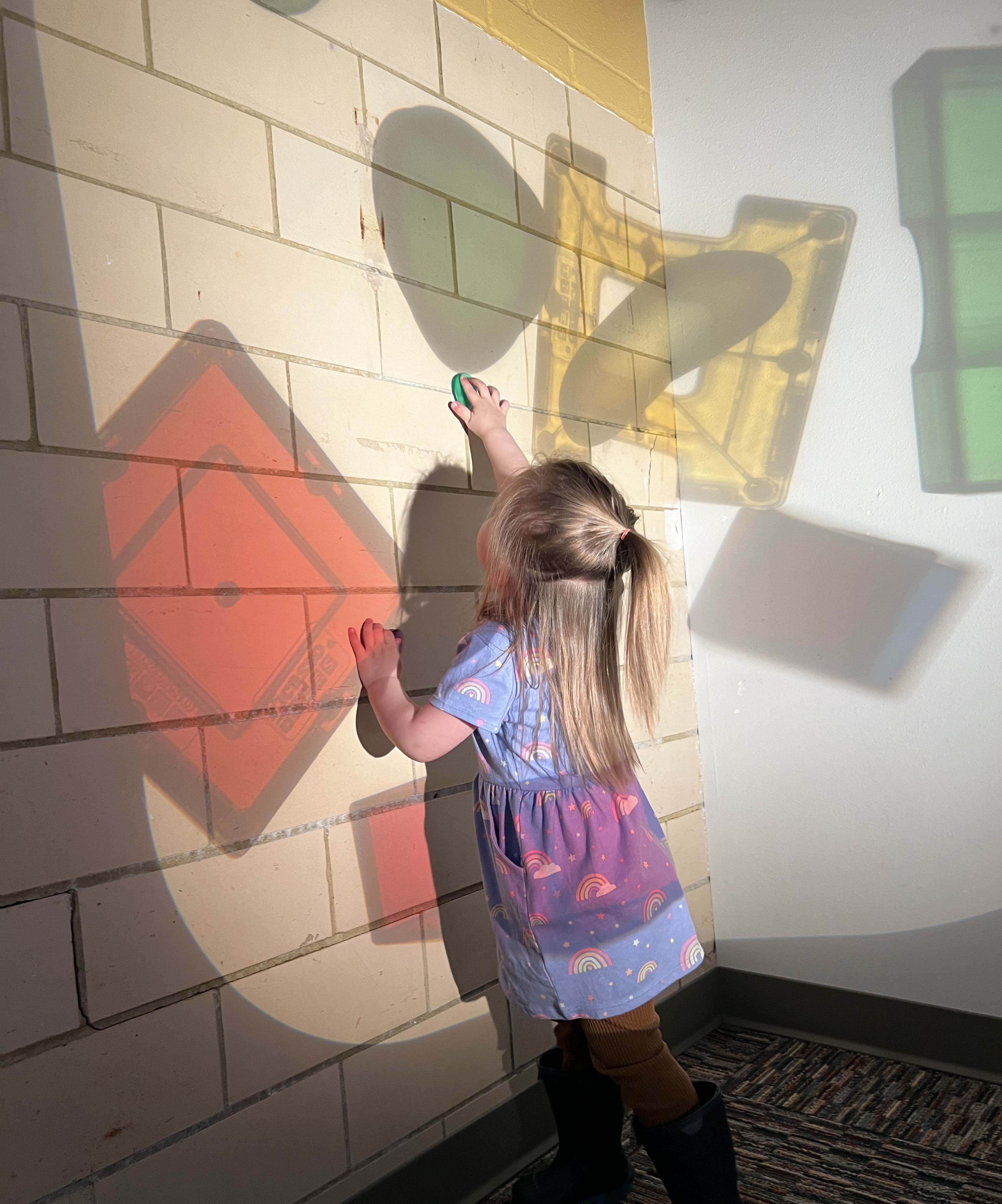 Young child touch shadows on a wall