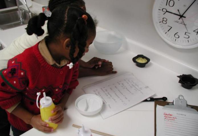 Child reading instructions before making a pancake