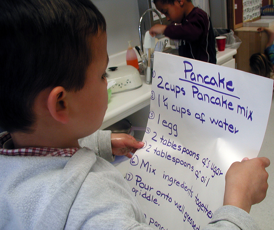 Young boy reading a recipe