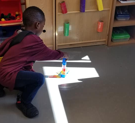 A boy stacking translucent blocks in a light