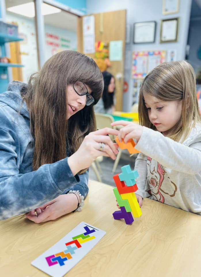 Adult helping a child with a block