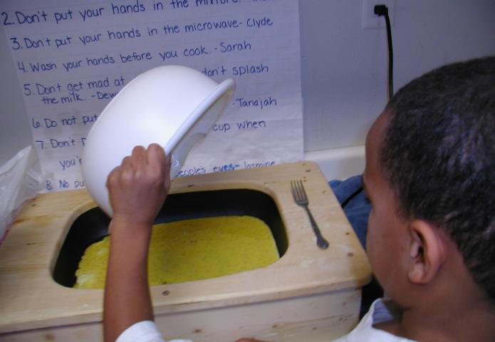 Child pouring egg solution into a skillet