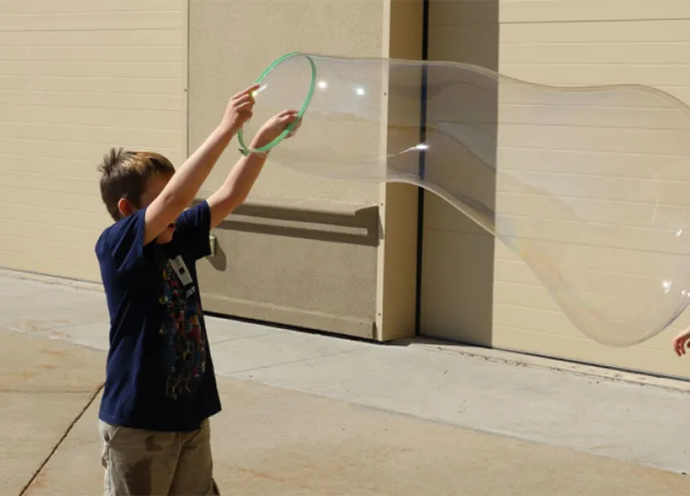 Child making a large bubble