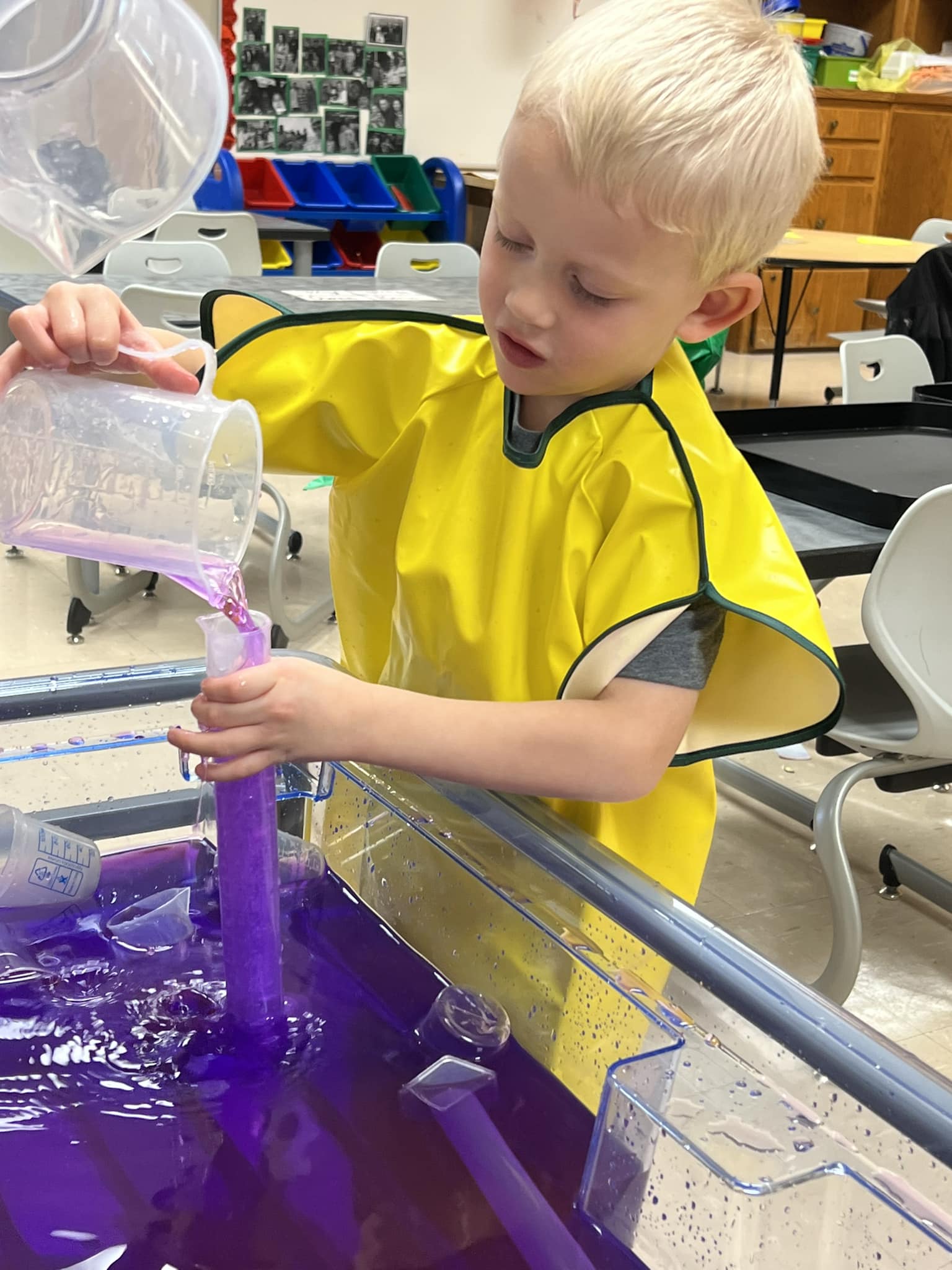 Young boy pour water from a beaker to a container