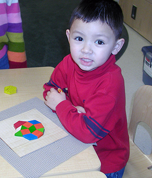 child playing with pattern blocks