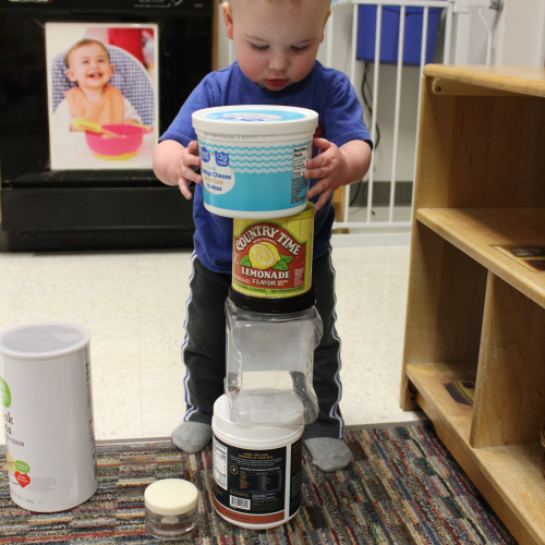 Toddler building with plastic containers