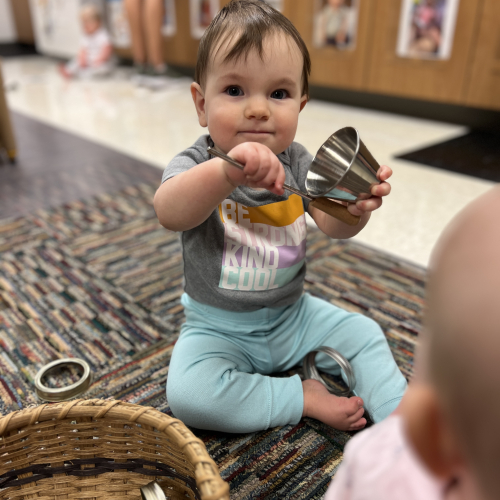 Infant holding a tin can