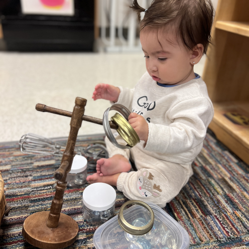 Infant putting rings on a wooden stand