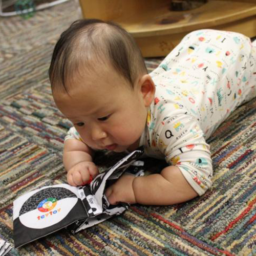 infant flipping through a book