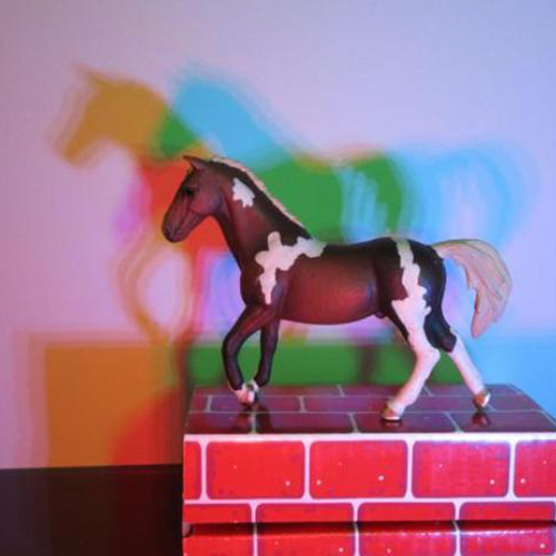 toy horse on block with three color shadow