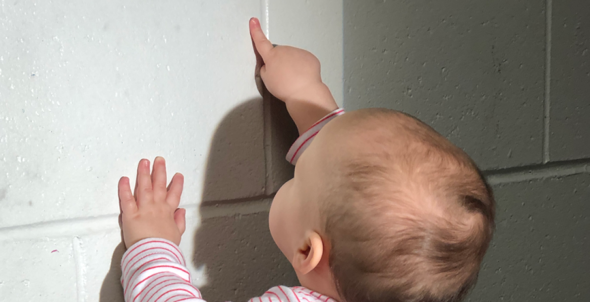 baby pointing at wall